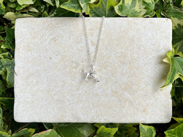 Silver cat playing with a ball necklace